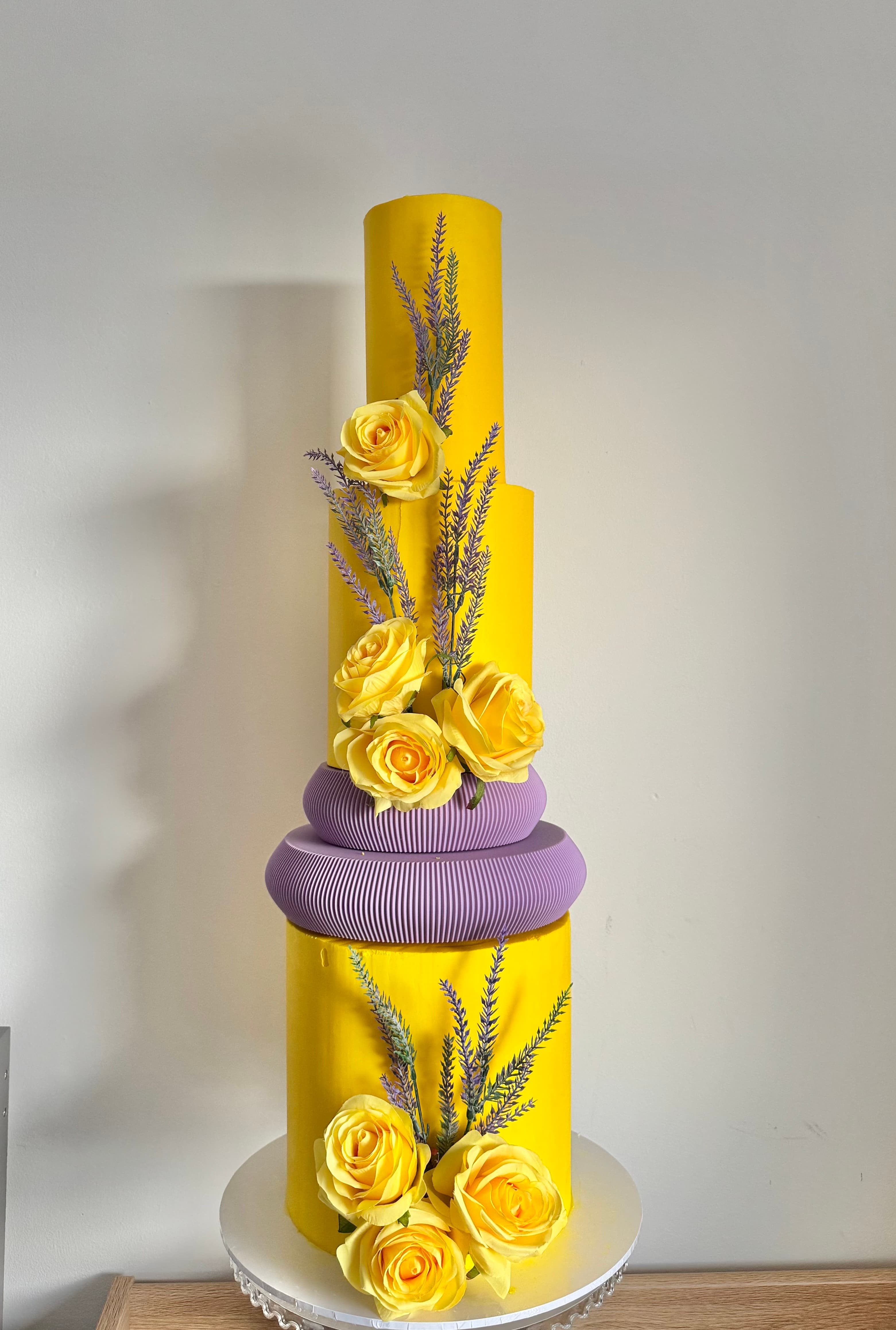 Tall yellow and lilac floral cake by NJF Cakes